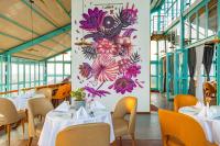 a restaurant with tables and chairs and a mural of flowers at Mhendo Hotel & Studio Suites in Kathmandu