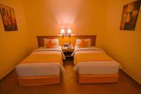 two twin beds in a room with a table at Charmillion Gardens Aquapark in Sharm El Sheikh