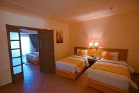 a hotel room with two beds and a door at Charmillion Gardens Aquapark in Sharm El Sheikh