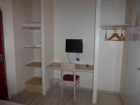 a room with a desk with a tv and a chair at La Godinière in Cholet