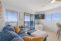 ein Wohnzimmer mit einem blauen Sofa und einem Fenster in der Unterkunft Sea Cabin 118 - Oceanfront in Myrtle Beach
