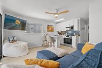 ein Wohnzimmer mit einer blauen Couch und einer Küche in der Unterkunft Sea Cabin 118 - Oceanfront in Myrtle Beach
