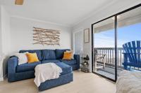 ein Wohnzimmer mit einer blauen Couch und einem Balkon in der Unterkunft Sea Cabin 118 - Oceanfront in Myrtle Beach