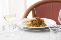 een bord eten op tafel met een glas wijn bij Hotel Degli Aranci in Vieste