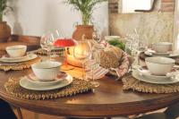 Una mesa de madera con platos y copas de vino encima. en Pátio das Ribeiras, en Almeirim