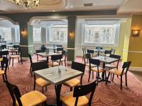 un ristorante con tavoli, sedie e finestre di Carlisle Station Hotel, Sure Hotel Collection by BW a Carlisle