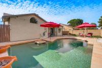 a swimming pool with red umbrellas in a yard at 3 Mi to Dtwn Home with Heated Pool in Gilbert in Gilbert