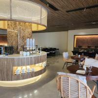 Un comedor con mesas y sillas y una lámpara de araña. en Elijah Hotel, en Dasmariñas