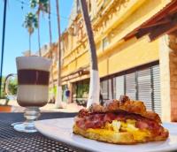 a plate with a breakfast sandwich and a drink on a table at Essenzia de Cancun in Cancún