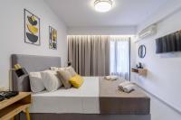 1 dormitorio blanco con 1 cama grande con almohadas amarillas en Soho Blue City Hotel, en Hersonissos