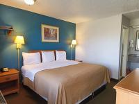 Un dormitorio con una cama grande en una habitación de hotel. en Executive Inn by OYO Kilgore North, en Kilgore