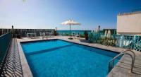 una piscina con sombrilla y el océano en Palm Inn Hotel Hurghda, en Hurghada