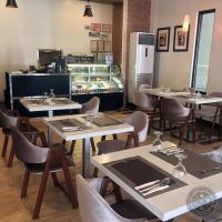 Un restaurante con mesas y sillas y un refrigerador. en Verjandel Hotel, en Manila