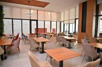 ドゥラスにあるAdria Palaceのテーブルと椅子と窓のあるレストラン