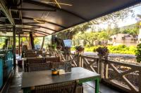 ein Restaurant mit einem Tisch und Stühlen auf einem Balkon in der Unterkunft Basilica Resort - Where Luxury Redefines in Mahabaleshwar