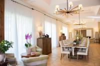 ein Esszimmer mit einem langen Tisch mit weißen Stühlen in der Unterkunft Feudo Del Biviere in Santa Ninfa