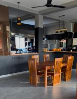 Una cocina con una mesa y sillas de madera. en Lucky Monkey Inn and Restaurant, en Weligama
