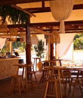 um grupo de mesas e cadeiras em um restaurante em Palladium Beach Hotel- Luxury Leading Hotels, Private Beach Included em Dhërmi