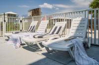 eine Reihe weißer Stühle auf einer Terrasse in der Unterkunft Cozy Girls Summer Getaway! Bungalow w Private Beach! in Gulf Shores