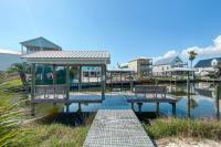 ein Dock mit Bänken auf einem Wasserkörper in der Unterkunft Cozy Girls Summer Getaway! Bungalow w Private Beach! in Gulf Shores