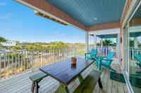 eine Veranda mit einem Holztisch und Stühlen in der Unterkunft Cozy Girls Summer Getaway! Bungalow w Private Beach! in Gulf Shores