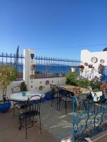 Un patio con mesas y sillas y vista al mar. en Maison d&#39;Hôtes Casa Azla, en Azla