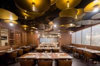 a restaurant with wooden tables and chairs and large lights at 威海卫大厦 Weihaiwei Hotel in Weihai