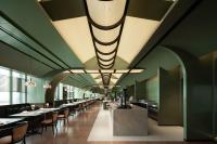 Un restaurante con paredes verdes, mesas y sillas. en 重庆Indition英迪逊酒店江北嘴金融城店, en Chongqing