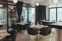 a restaurant with tables and chairs and windows at Accra Luxury Apartments @ The Signature in Accra