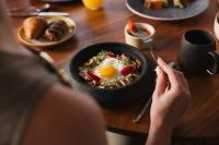 een persoon aan een tafel met een kom eten bij Almare, a Luxury Collection Resort, Isla Mujeres Cancun, Adult All-Inclusive in Isla Mujeres