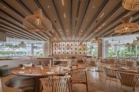 een eetkamer met tafels en stoelen en ramen bij Almare, a Luxury Collection Resort, Isla Mujeres Cancun, Adult All-Inclusive in Isla Mujeres