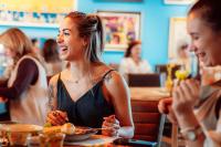 a woman sitting at a table with a plate of food at Boutique Hotel Casa Art in Oreshak