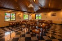 ein Restaurant mit Tischen und Stühlen auf einem karierten Boden in der Unterkunft Aashiyana Luxury Cottages in Khilchīpur