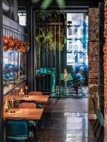 ein Restaurant mit Holztischen und Stühlen in einem Raum in der Unterkunft Boutiquehotel Staats in Haarlem