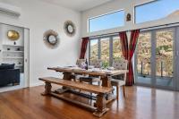 ein Esszimmer mit einem Holztisch und Stühlen in der Unterkunft Huge &amp; Stylish on Shotover 4 Bedrooms in Queenstown