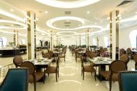 Un restaurante con mesas y sillas en una sala. en Adamo Hotel Hung Yen - Free Daily Access To The Jimjilbang, en HÆ°ng YÃªn