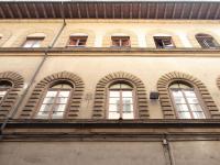 un edificio con ventanas arqueadas en un lateral en Berardi Palace Apartments, en Florencia