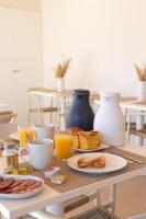 un tavolo per la colazione con cibi per la colazione e succo d'arancia di Hostal Lóbrega a Torrecilla en Cameros