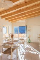 una sala da pranzo con tavoli, sedie e finestre di Hostal Lóbrega a Torrecilla en Cameros