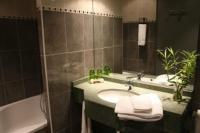 a bathroom with a sink and a bath tub at Hôtel Beatus in Cambrai