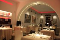 チェファルにあるLa Casa di Giòの白いテーブルと椅子とアーチのあるレストラン