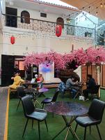 un grupo de personas sentadas en mesas en una habitación con flores rosas en UMAI Palace, en Arequipa