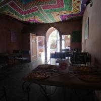 a room with a colorful ceiling with tables and chairs at "Par 4 chemins" Atypical Stopover in Nouakchott