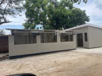 a small white building with a tree in the background at Idyllic Inn in Lilongwe