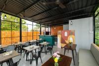 Un restaurante con mesas, sillas y ventanas. en Villa Kayu Amertha, en Gitgit
