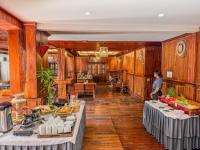 Uma mulher numa sala com mesas e comida. em Siem Reap Center Hotel em Siem Reap