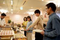 a group of people standing around a buffet of food at Grand Lectore Yugawara - TKP Hotels & Resorts in Yugawara