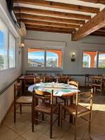 a dining room with a table and chairs and windows at Hôtel La Casera in Clarac