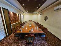 uma grande sala de conferências com uma mesa longa e cadeiras em Sathyam Grand Resorts, Sriperumbudur em Sriperumbudur