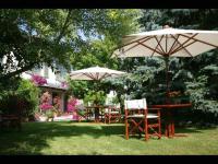 two tables and chairs with umbrellas in a yard at Hôtel Beatus in Cambrai